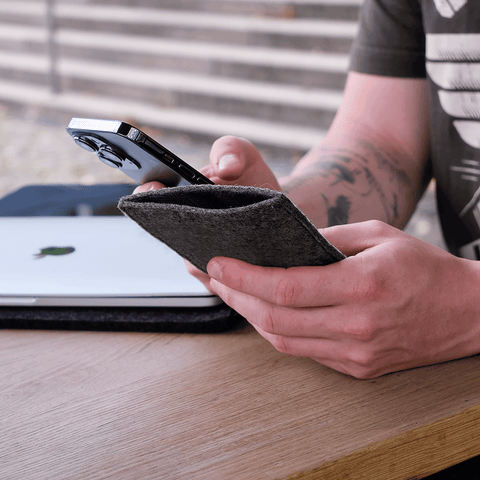 Person mit einer stilvollen anthrazitfarbenen Smartphone-Hülle für das Samsung Galaxy A37 aus Filz und Baumwolle.