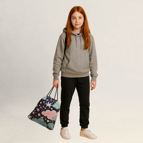 Person hält einen Turnbeutel mit Sternenhimmel-Design locker in der Hand.